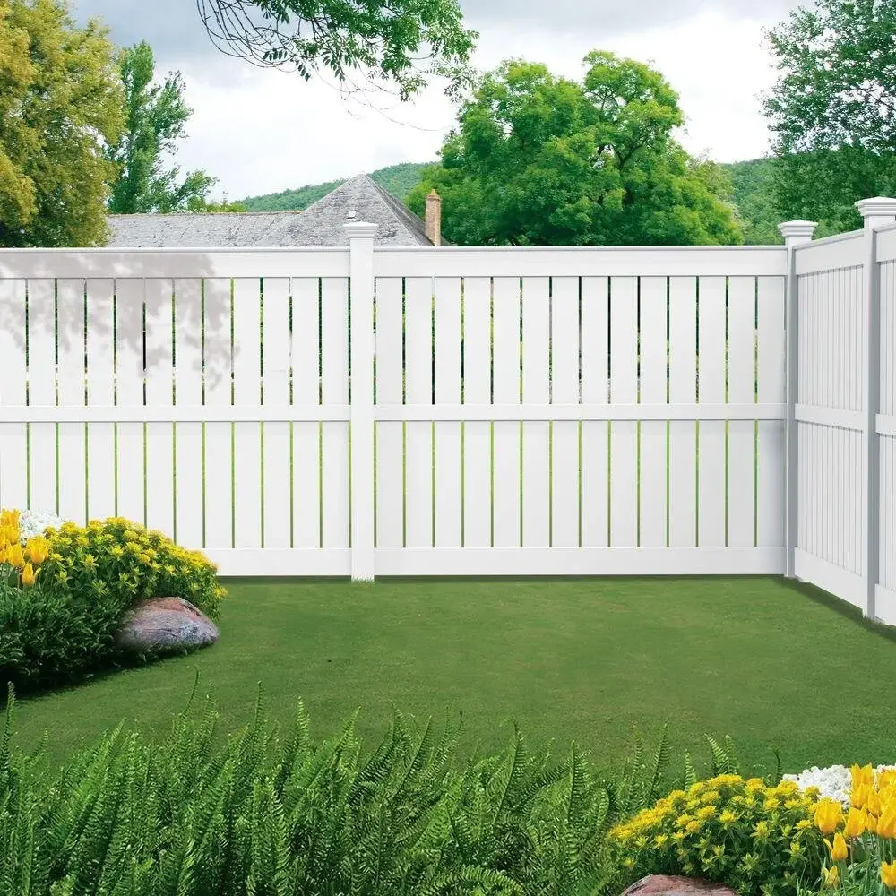 White vinyl privacy fence enclosing a landscaped backyard